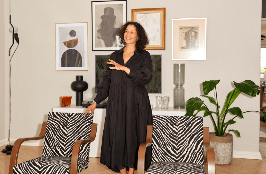 A person standing between two zebra striped chairs.