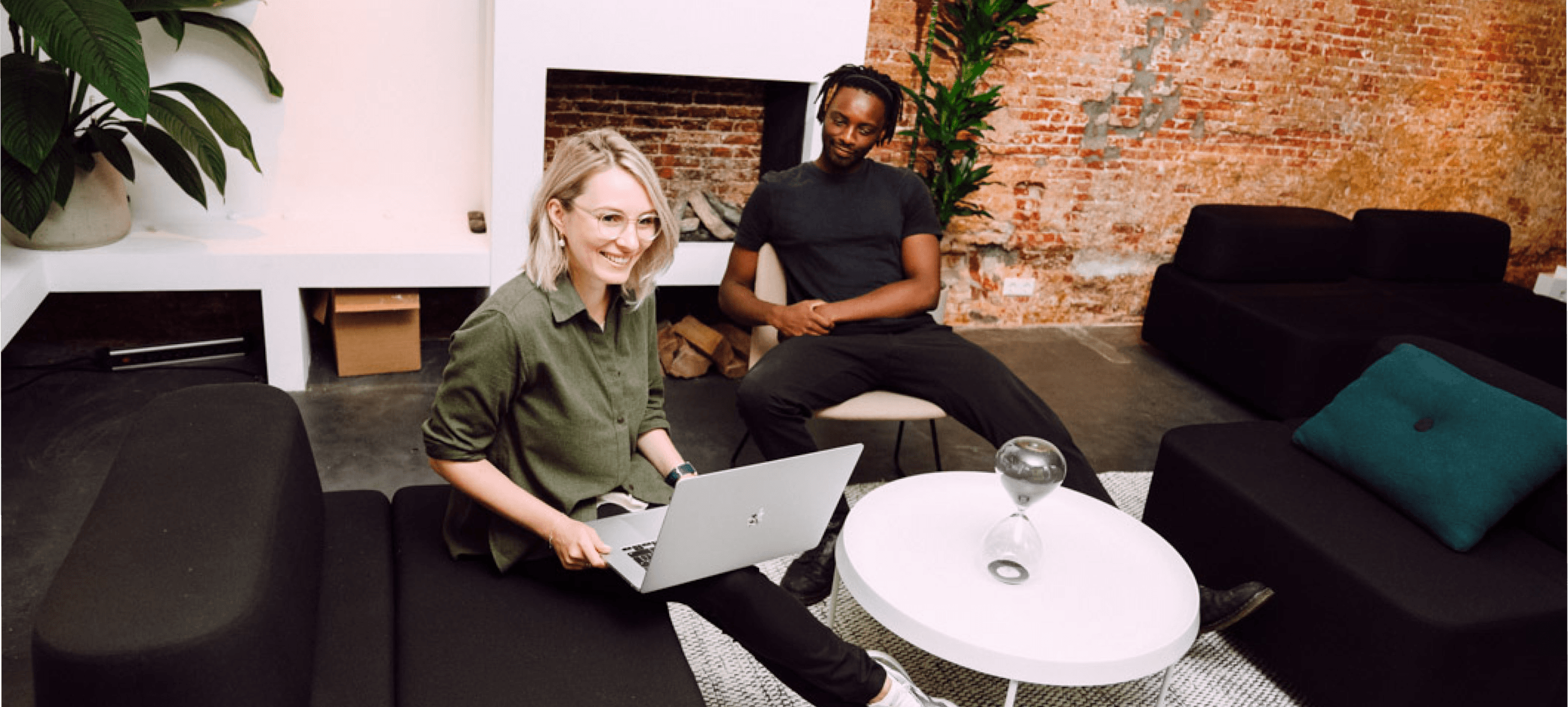 Two smiling people sitting down.