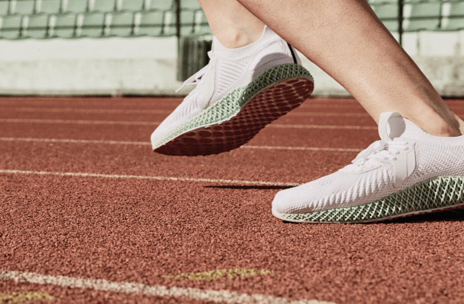 A close up of a person's running shoes on a track.