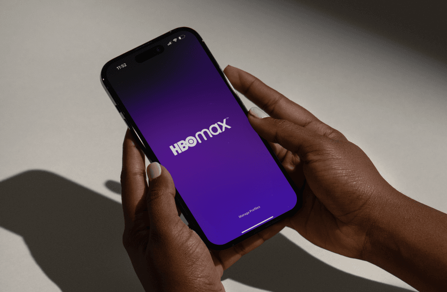 A person holding a phone with the HBO Max landing screen on it.